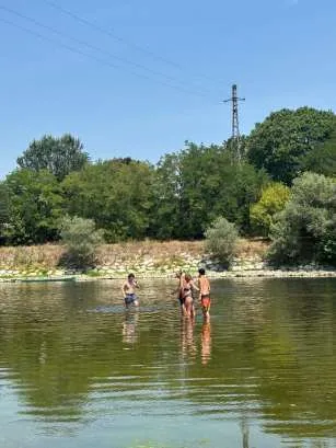 Tre ragazzi in piedi nell'acqua bassa di un fiume, durante una gita fuori porta