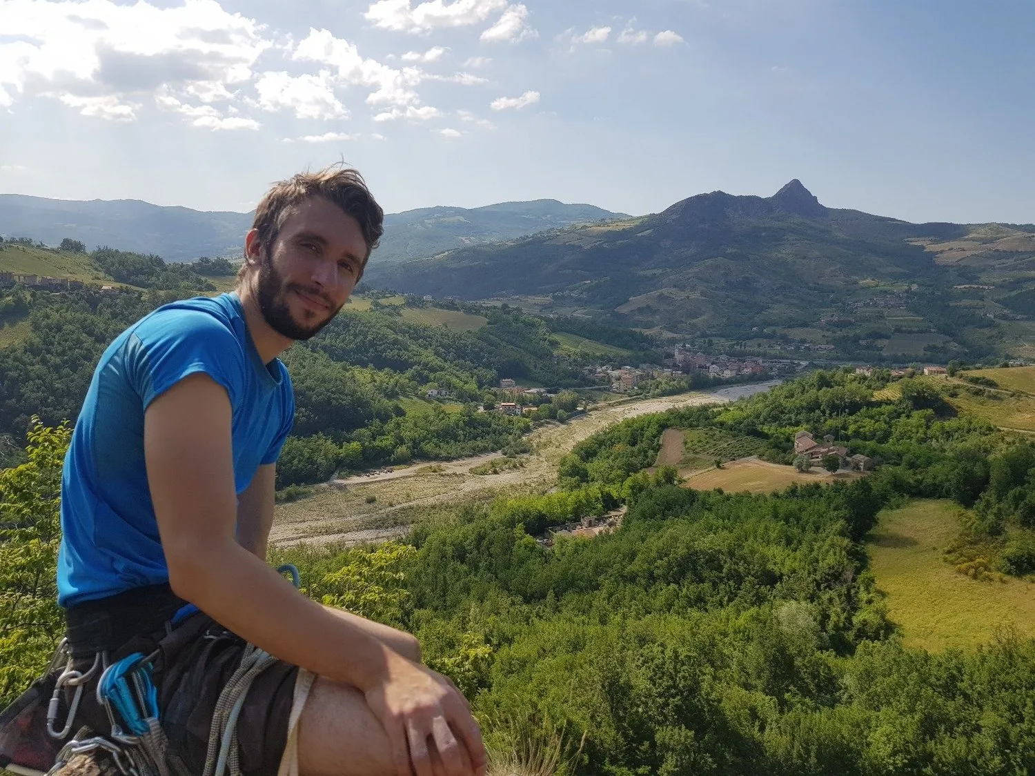 Ale seduto in cima a una falesia, con la valle sullo sfondo