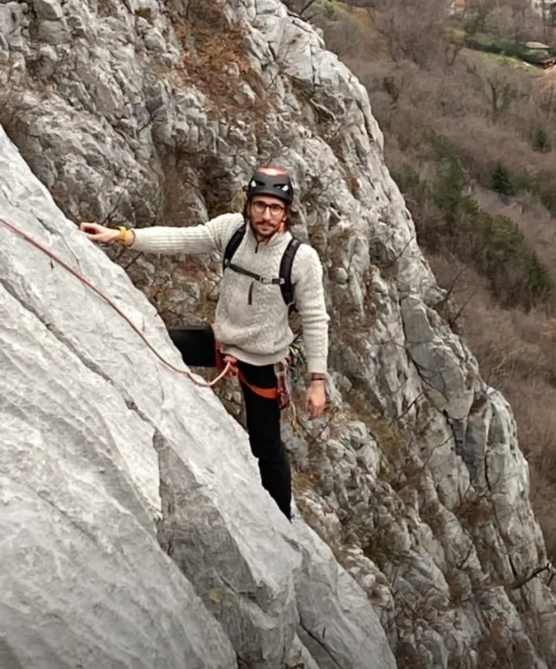 Ale in arrampicata su una parete di roccia