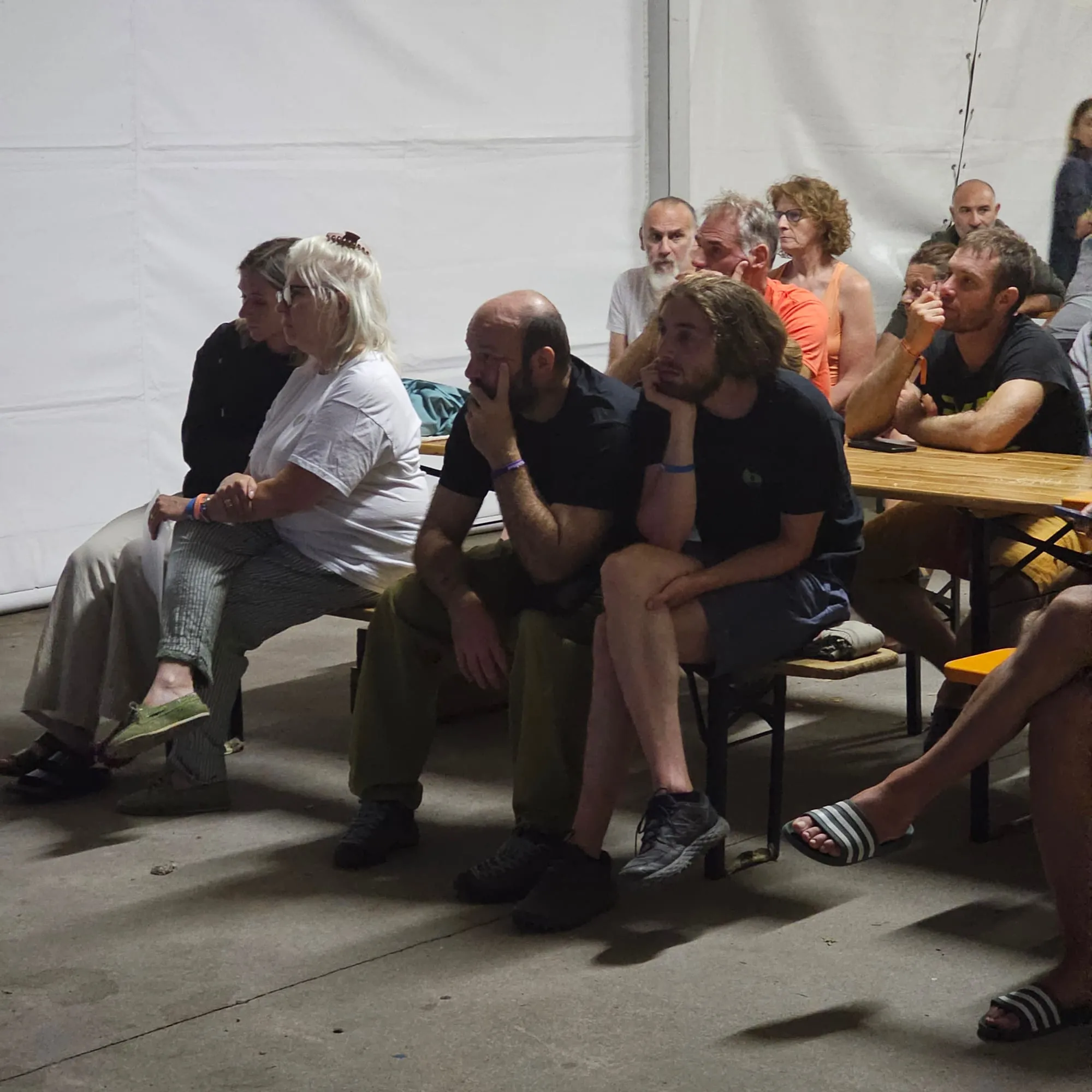 Il pubblico seduto sulle panche del tendone che segue la presentazione